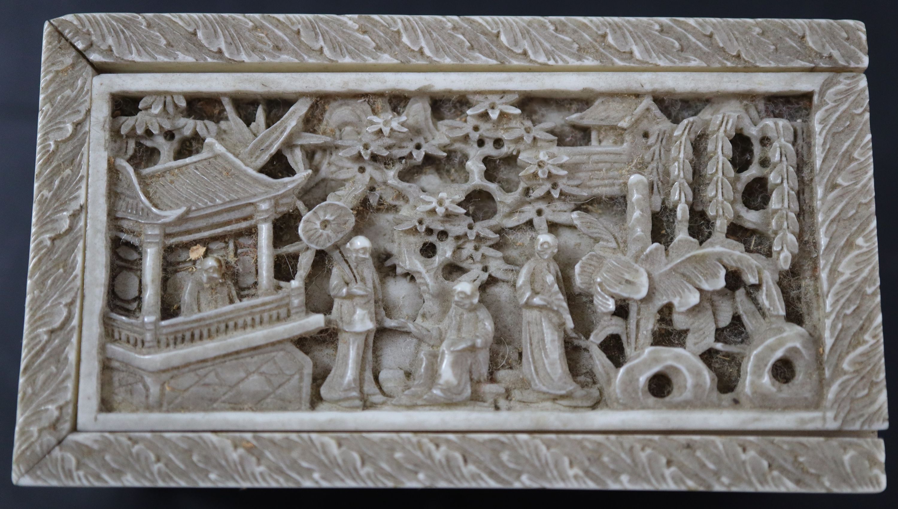 A 19th century Chinese relief carved ivory box housing plain and red stained ivory alphabet letters, 6.75cm